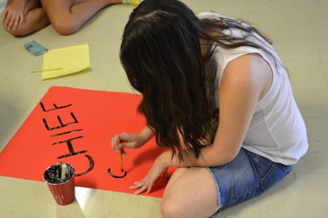 Nicole McGarity paints the Chiefs Squad sign.