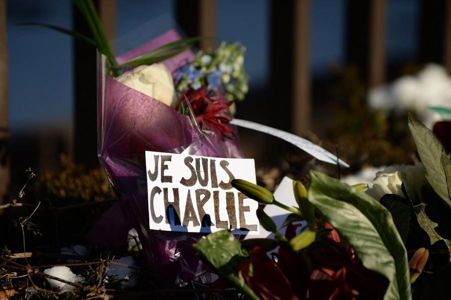 Flowers are left with notes written in French reading I am Charlie and rest in peace near the fence at the French Embassy over a flower memorial January 8, 2015 in Washington, D.C., in response to the attack on satirical French magazine Charlie Hebdo by three gunmen yesterday that took the lives of 12 people. 