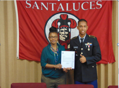 Mrs. Robinson and Dominic Alexandre in the principals conference room accepting his scholarship.