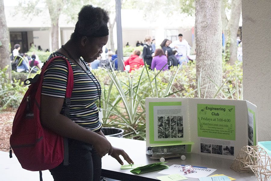 A student looks at the Engineering Club table.