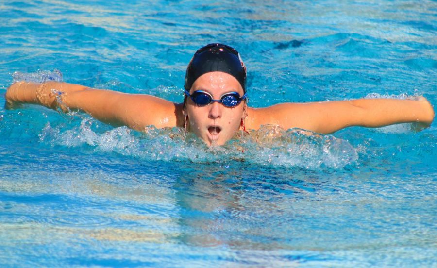 Emily Black places first in her race with the butterfly stroke.