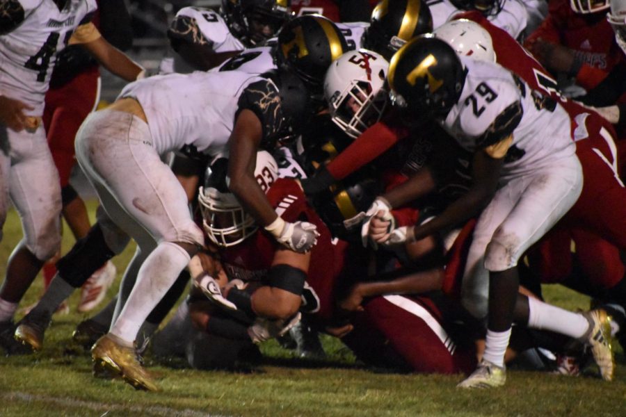 Coe Jr. grasps the ball as he gets covered in the Titans defensive line.