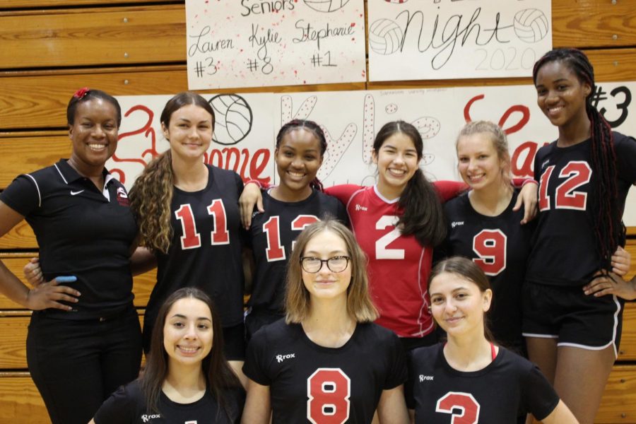 Laura Garcia (in red) alongside her Varsity Volleyball teammates