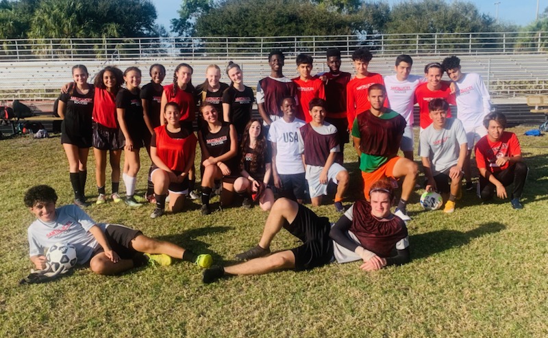 The boys and girls soccer teams coming together for a photo during practice. 