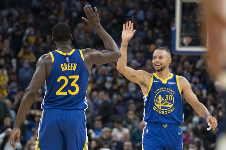 Forward Draymond Green and Guard Stephen Curry going in for a celebratory high five.