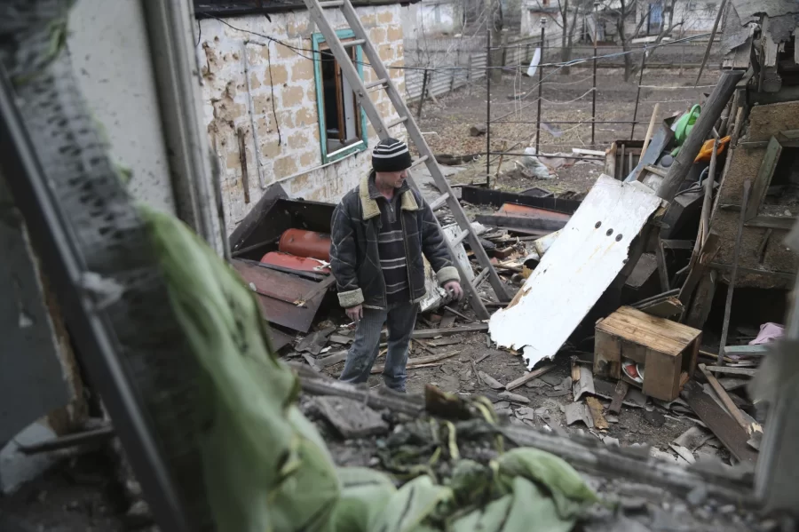 A Ukrainian resident standing over his home after a missile attack.