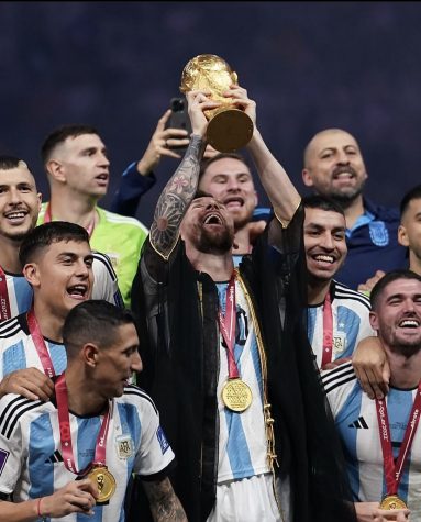 Lionel Messi holds up the third World Cup trophy for Argentina.
