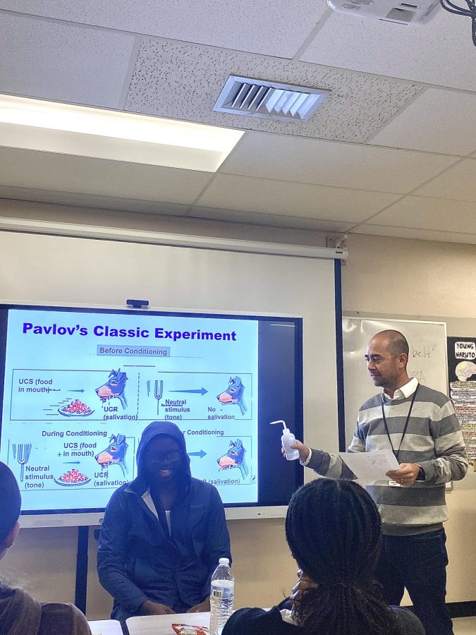 Junior Louckens Philippe helping Mr. Gray demonstrate Pavlovs Classical Conditioning Theory.