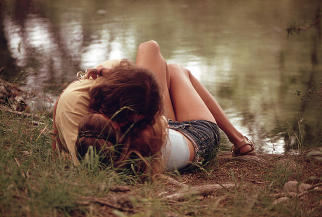 Teenagers laying on the grass.