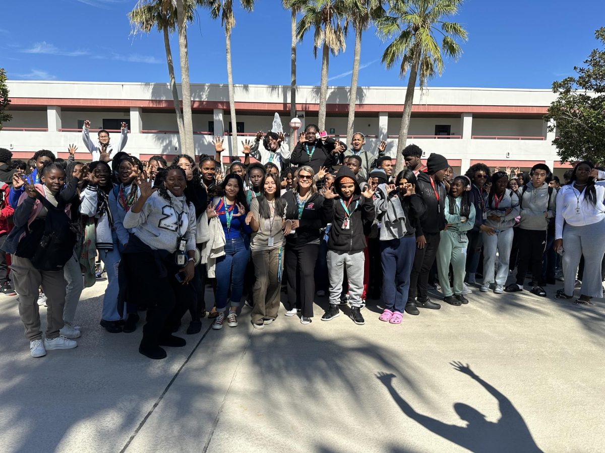 Ms. Lescas and Ms. Mawali join the 10th grade students at the fountain for a photo opp. 