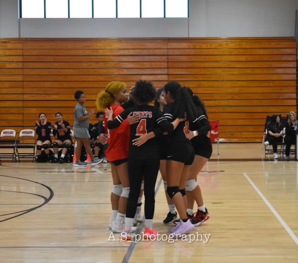 The Santaluces girls volleyball team hurling after a rally. 