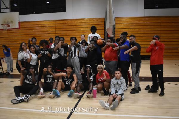 The teachers and students posing together after a successful game. 