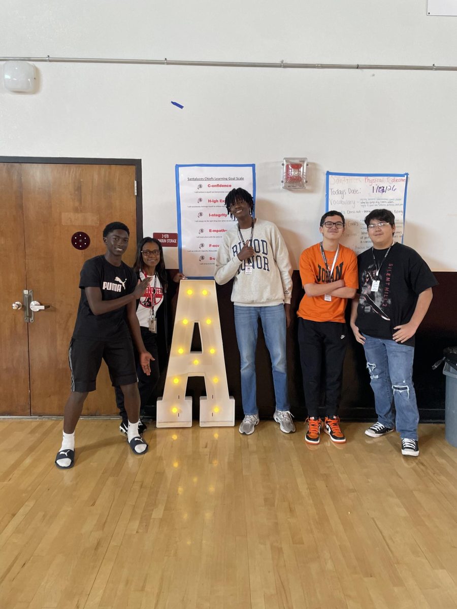 students posing with mrs robinson during honor roll pizza party 