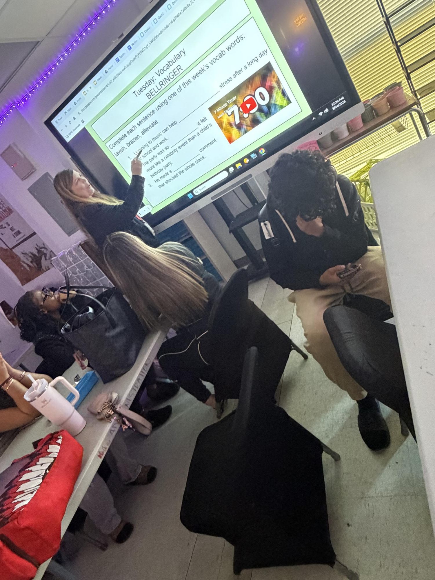 Student on their phone while teacher is talking 